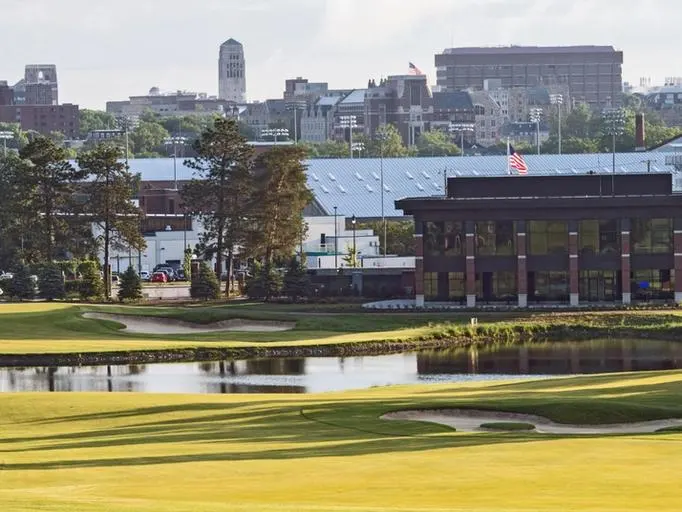 The golf course with campus buildings in the distance