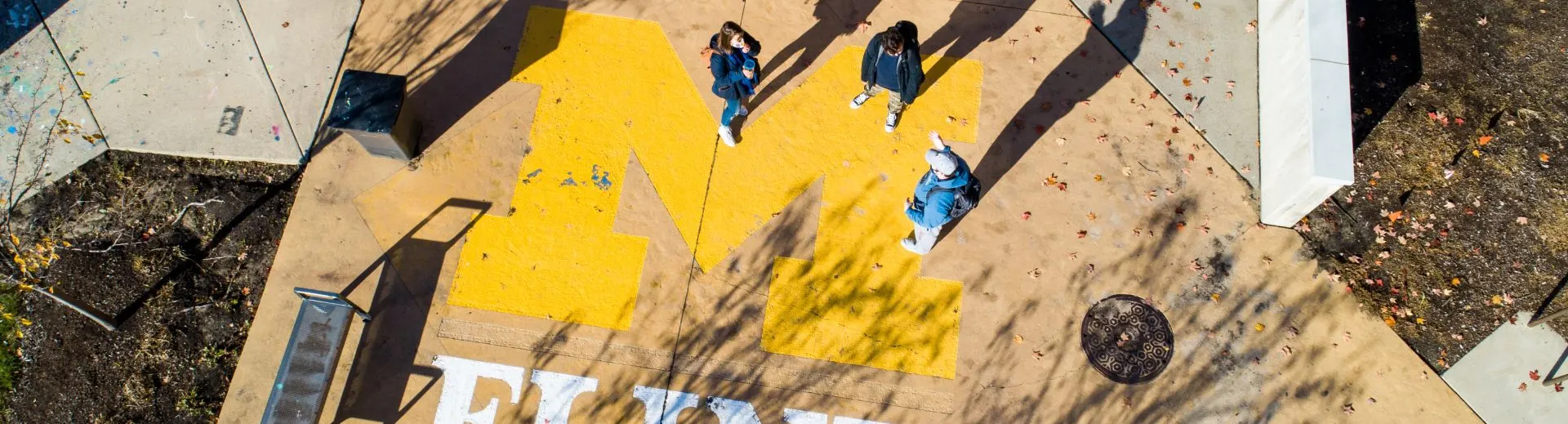 People walking over the block M on UM-Flint's campus