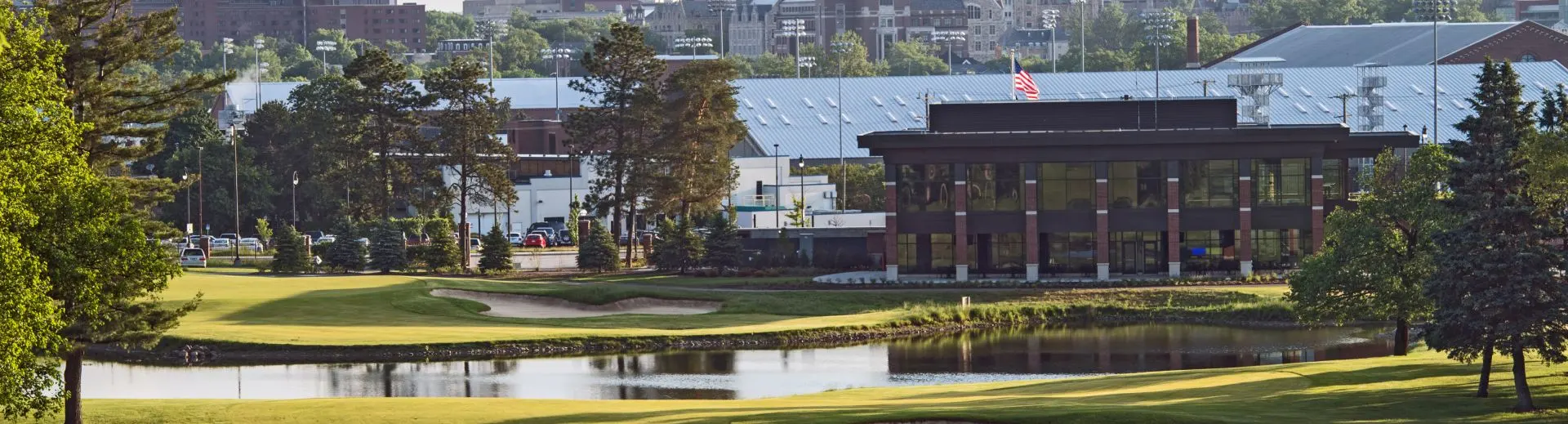 The golf course with campus buildings in the distance